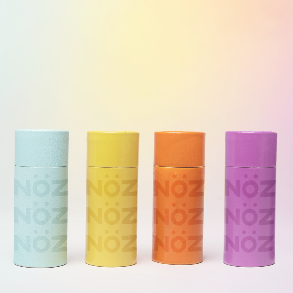 Front view of four Noz products shown in blue, yellow, orange, and purple varieties 