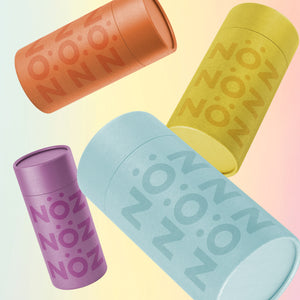 Close up shot of floating angled noz products shown in orange, yellow, purple, and blue from left to right