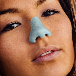 close up of freckled girl with a lifeguard nose using Noz's blue variety sunscreen  